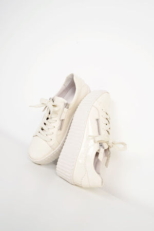 An image of a pair of cream lace-up trainers